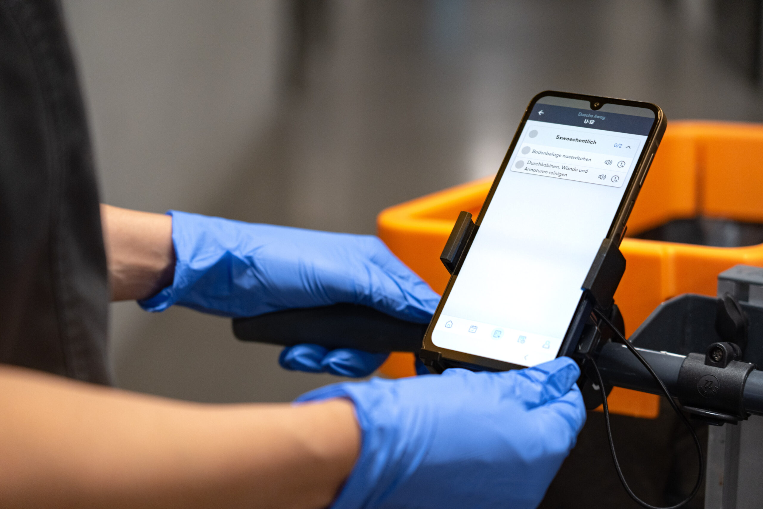 Smartphone auf Halterung an Reinigungswagen