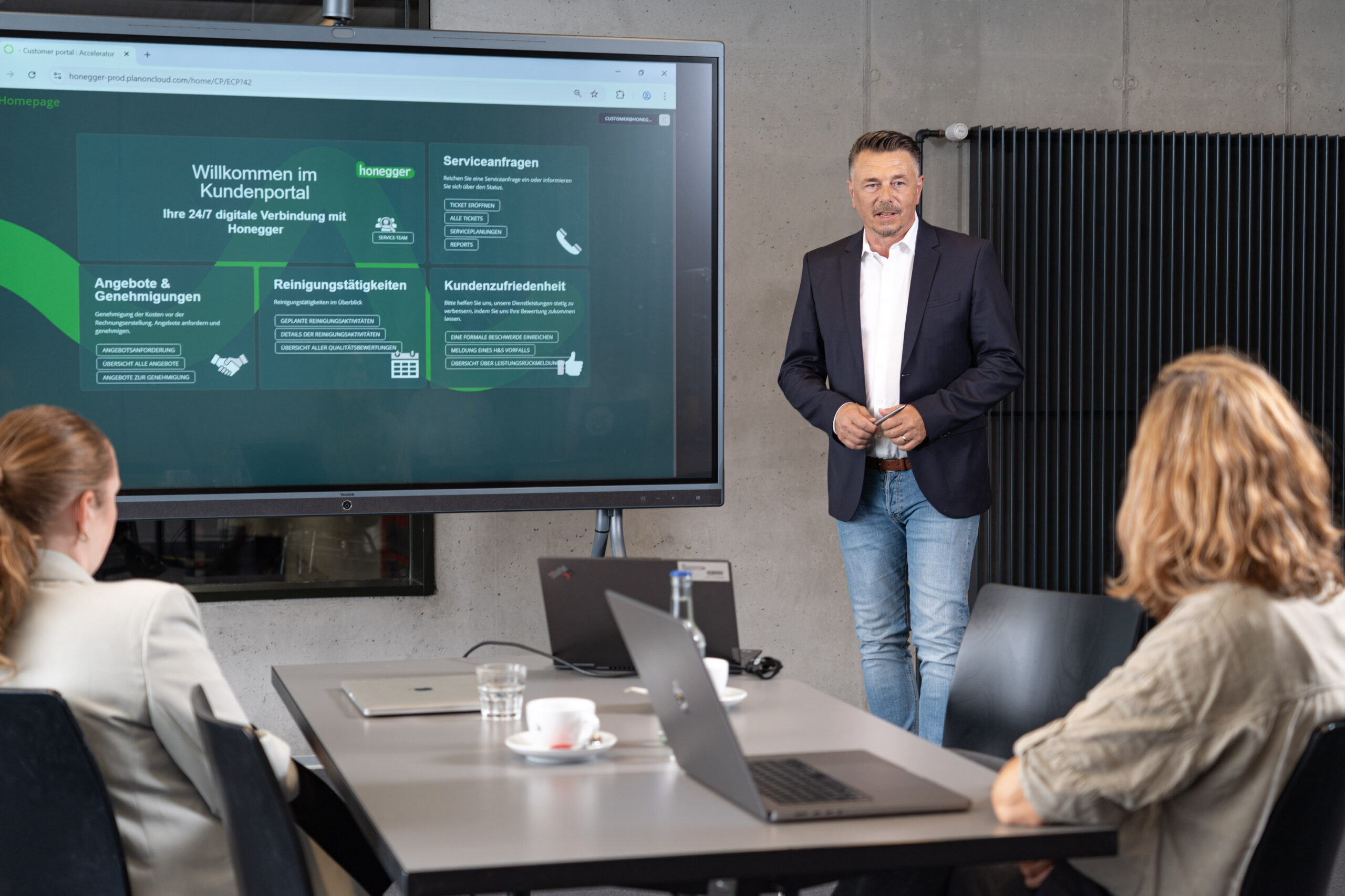 Ein Mitarbeiter der Honegger AG präsentiert seinen Kundinnen und Kunden ein digitales Kundenportal